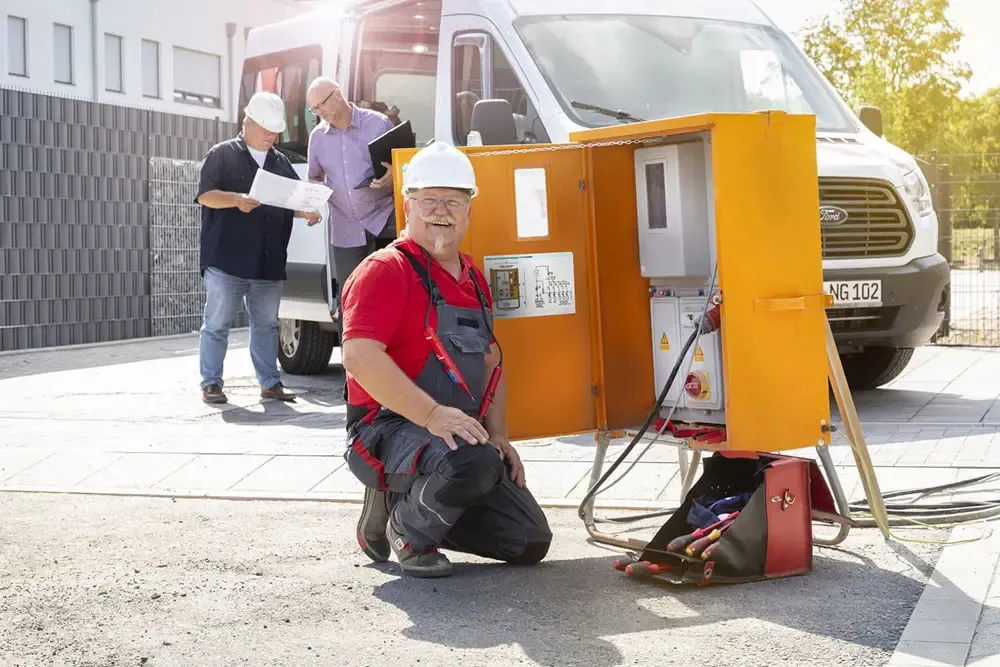 NGN Kollege kniend vor Baustromkasten