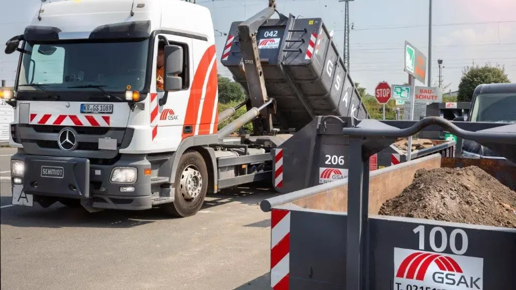 LKW von der GSAK hebt einen Container an