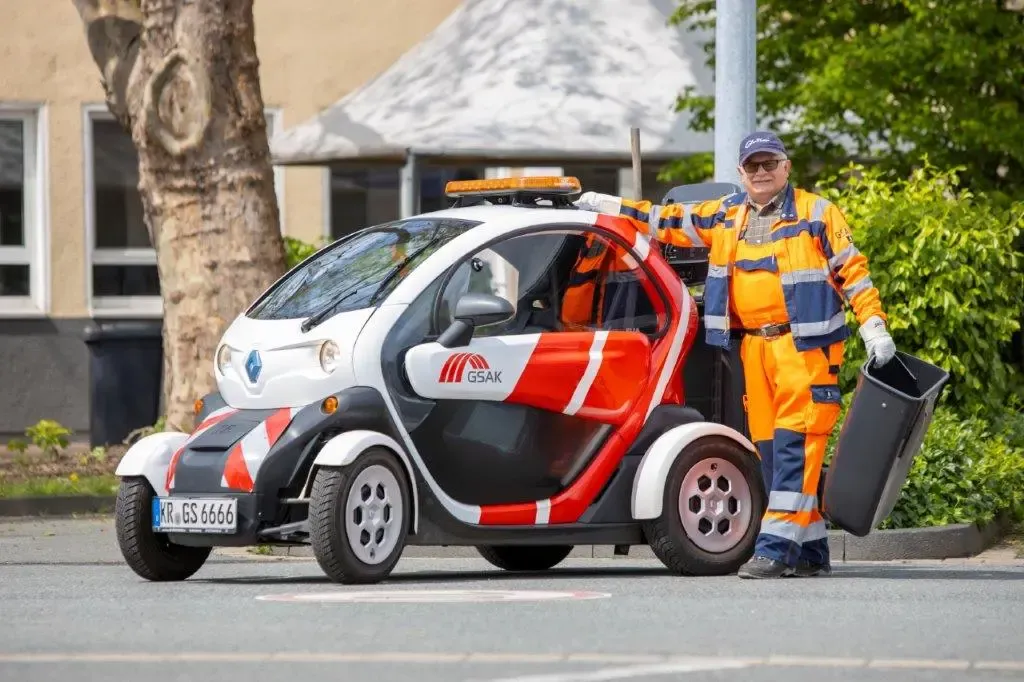 Mitarbeiter von der GSAK mit einem E-Auto