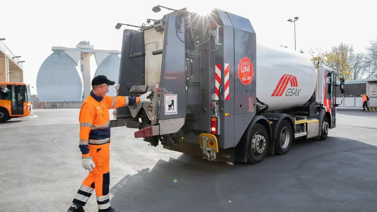 GSAK Mitarbeiter hinter einem Müllwagen