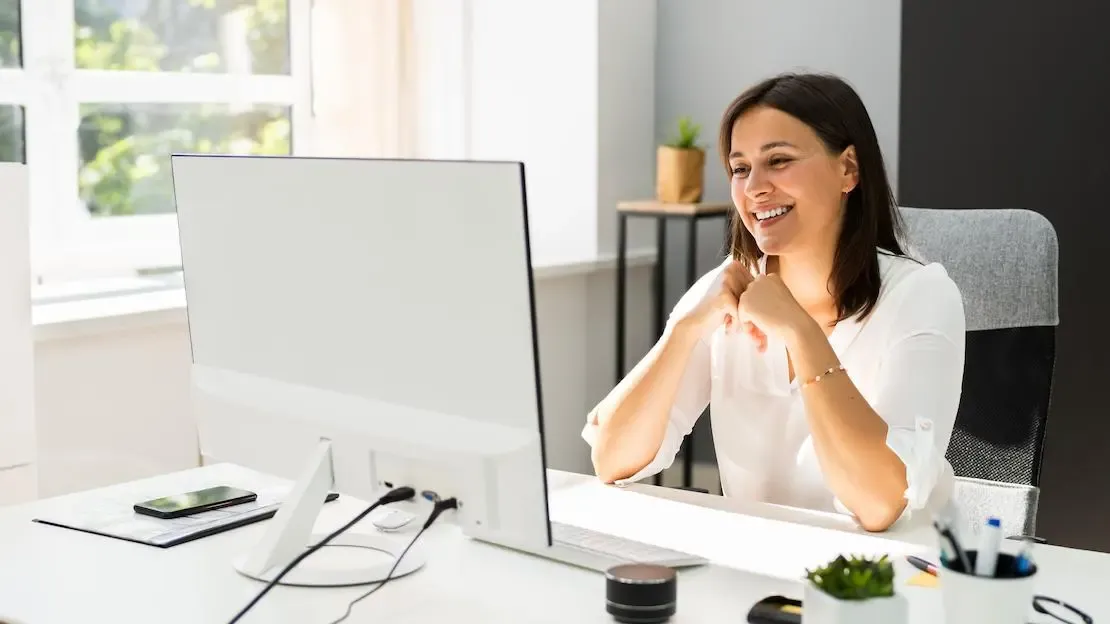 GSAK Mitarbeiterin sitzt lächelnd vor dem Computer