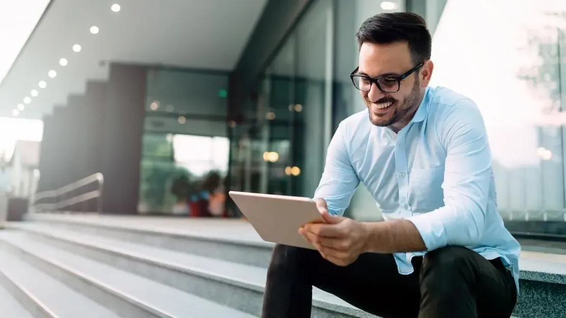 swk-service-versprechen-geld-zurueck-garantie.webp Mann mit Tablet sitzt auf der Treppe