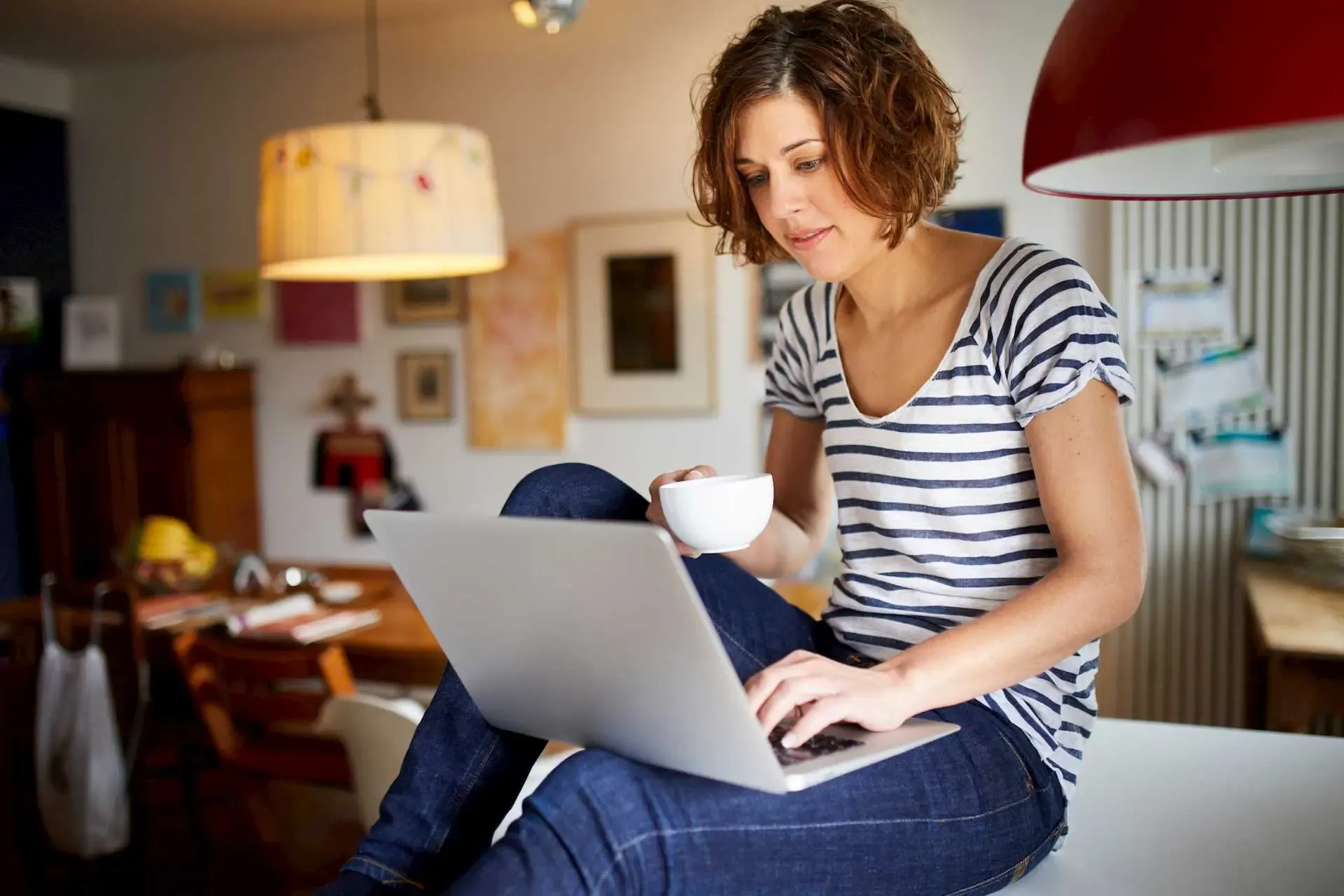 Frau sitzt mit Laptop auf einem Tisch und liest die Lieferbedingungen der SWK Energie
